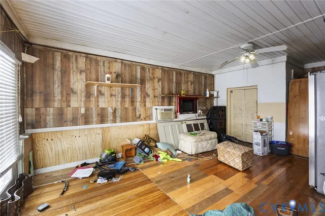 a living room with furniture a wooden floor and next to a window