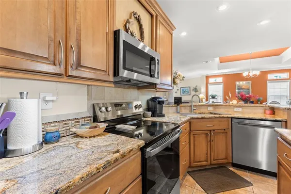 a kitchen with stainless steel appliances granite countertop a sink a stove and a microwave