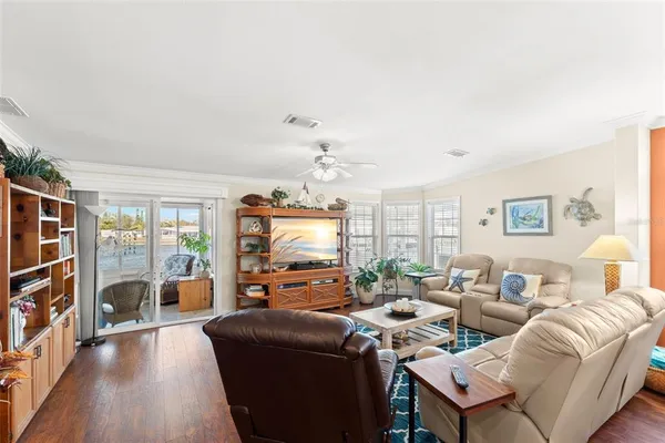 a living room with furniture a flat screen tv and a window