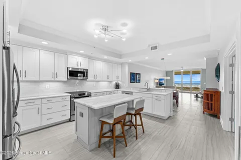 a view of living room kitchen with granite countertop a fireplace and a window