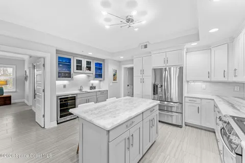a kitchen with a sink a stove a refrigerator and white cabinets