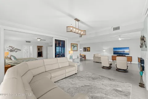 a living room with furniture and a chandelier
