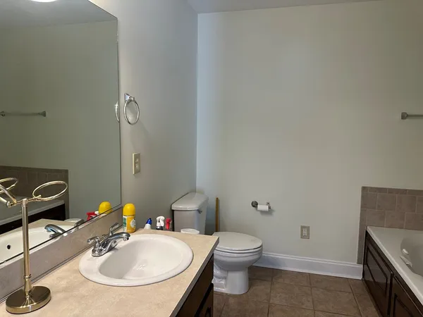 a bathroom with a sink toilet and mirror