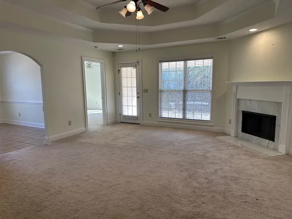 an empty room with windows and fireplace