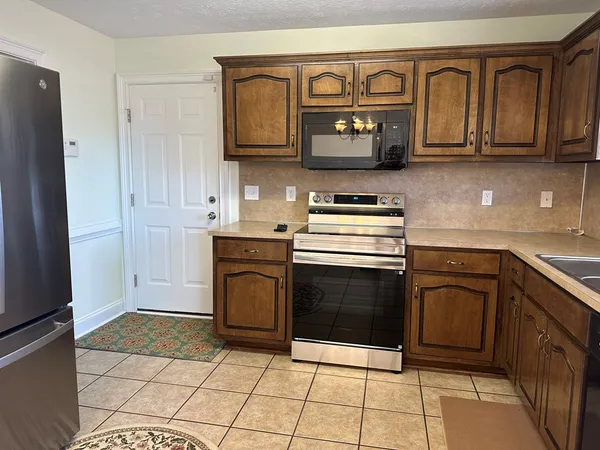 a kitchen with stainless steel appliances granite countertop a stove a microwave and a refrigerator