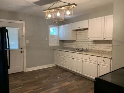 a kitchen with granite countertop white cabinets and white appliances