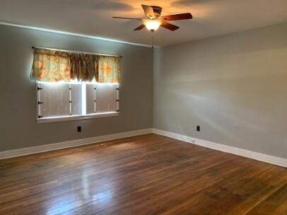 3208 33rd Street Lubbock, TX 79410 - Photo 4 of 14 a view of an empty room with wooden floor and a window