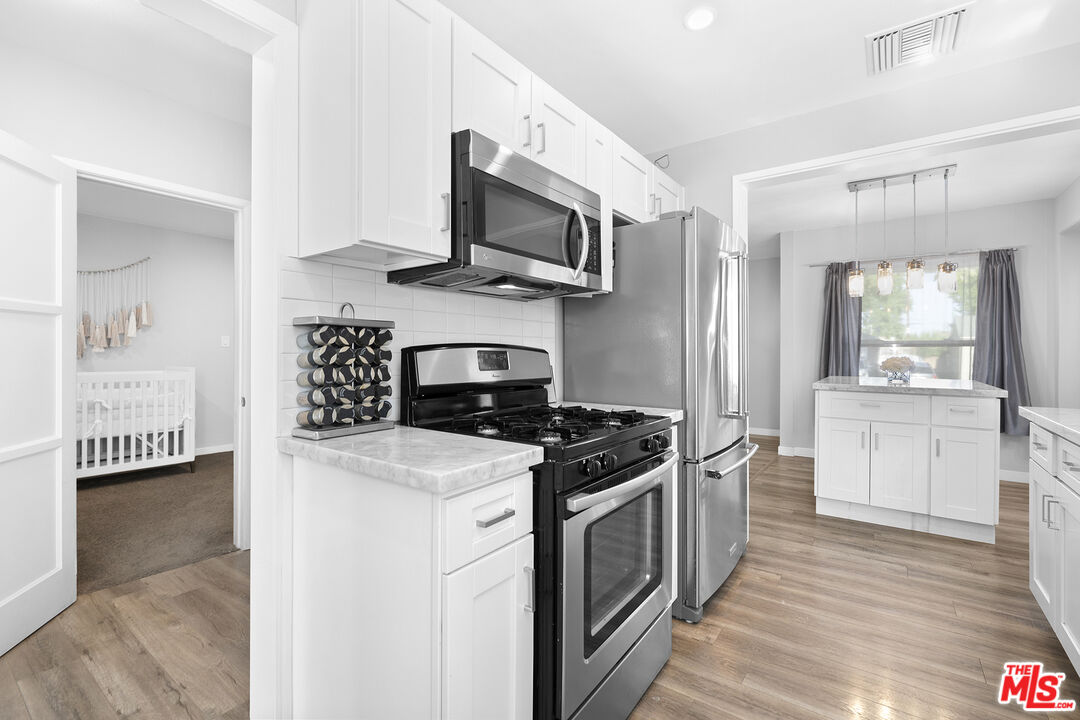 6521 Balcom Avenue Reseda, CA 91335 - Photo 11 of 35 a kitchen with stainless steel appliances granite countertop a stove and a sink