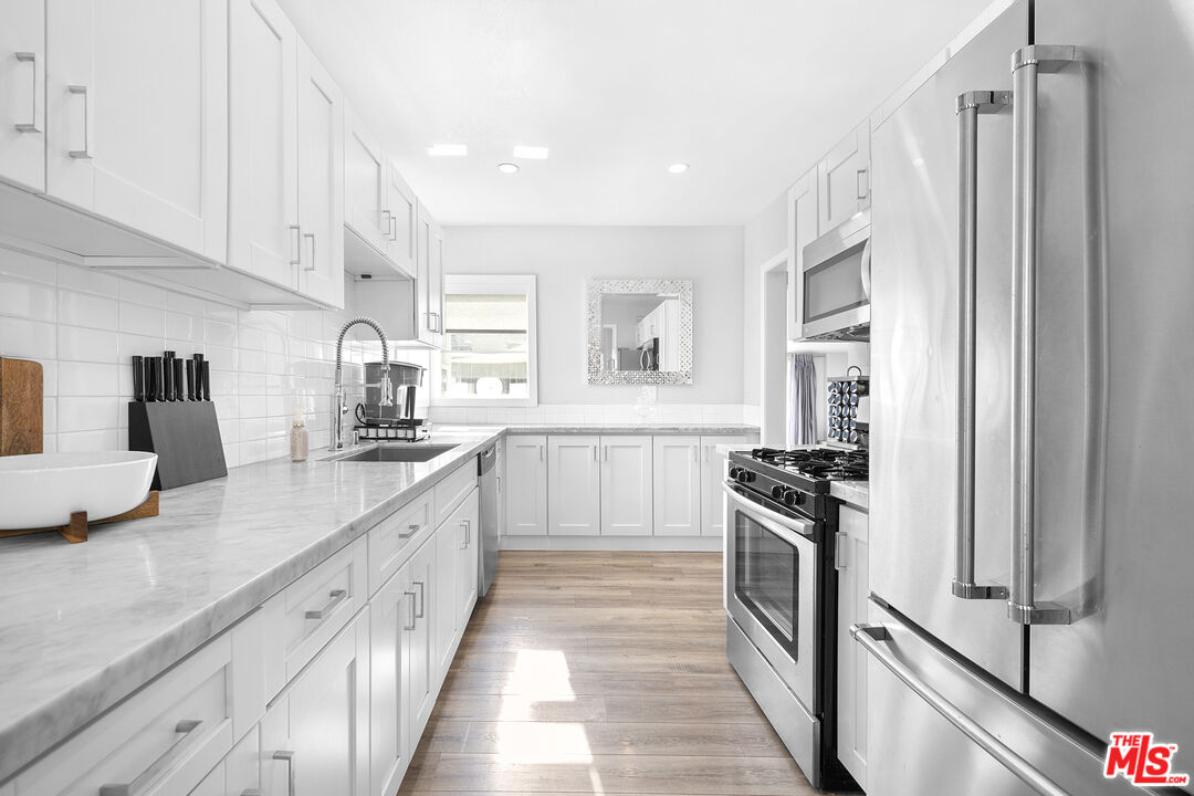 6521 Balcom Avenue Reseda, CA 91335 - Photo 9 of 35 a kitchen with a sink stove and refrigerator