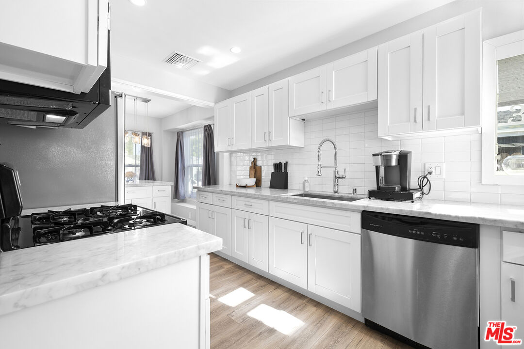6521 Balcom Avenue Reseda, CA 91335 - Photo 10 of 35 a kitchen with a sink stove and cabinets
