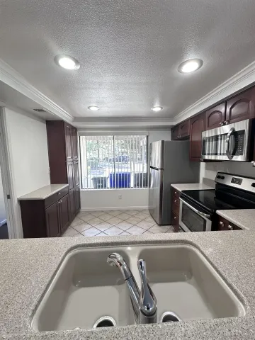 a view of kitchen island with stainless steel appliances granite countertop sink