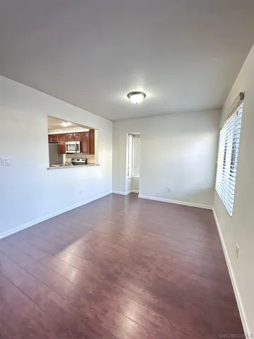 a view of a livingroom with wooden floor and window