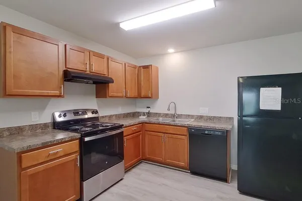 a kitchen with stainless steel appliances granite countertop a stove a sink and a microwave