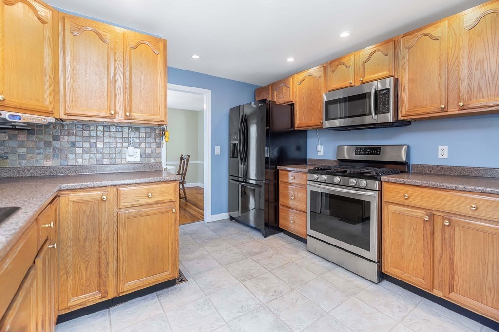18 Redstone Drive Springfield, MA 01118 - Photo 12 of 31 a kitchen with stainless steel appliances granite countertop a stove and a microwave