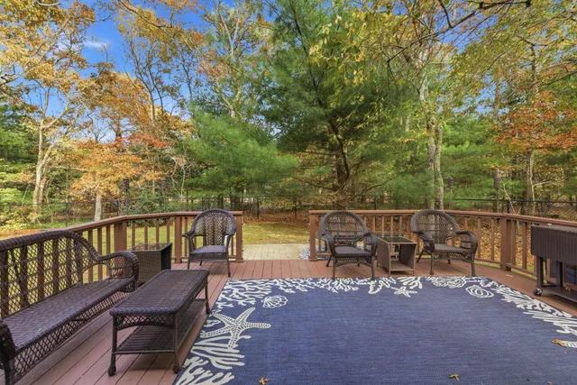 a view of a balcony with chairs and wooden fence