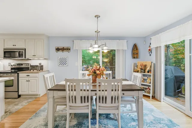 a dining room with furniture a chandelier and window