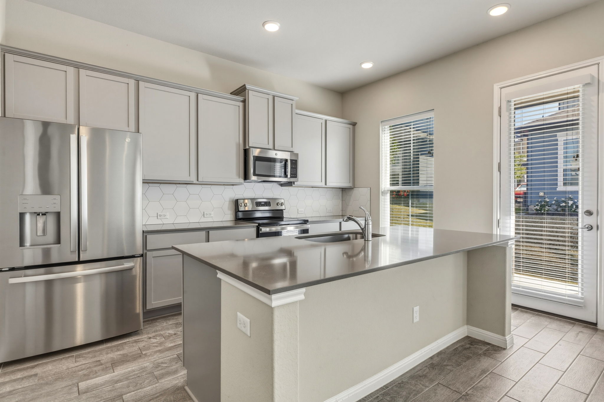 1015 Vista View Drive, Unit 2102 Georgetown, TX 78626 - Photo 12 of 40 a kitchen with stainless steel appliances granite countertop a refrigerator a sink a stove a microwave and island