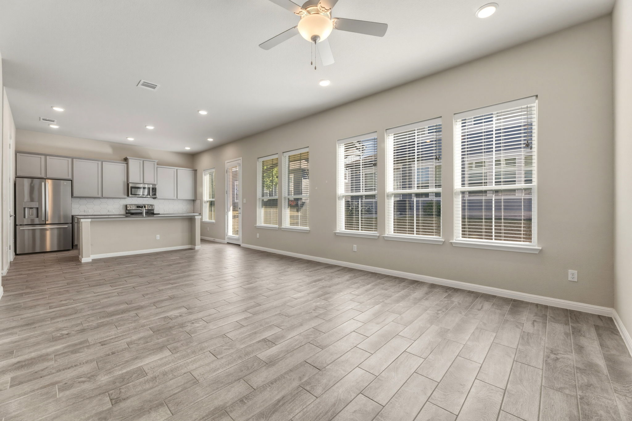 1015 Vista View Drive, Unit 2102 Georgetown, TX 78626 - Photo 8 of 40 a view of an empty room with wooden floor and a kitchen