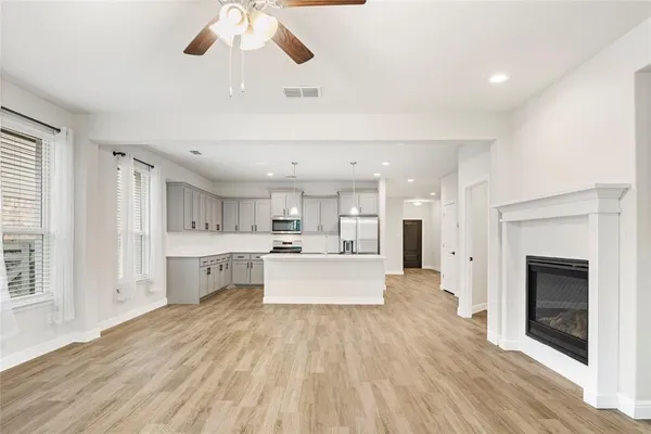 a large white kitchen with a large window a stove and white cabinets