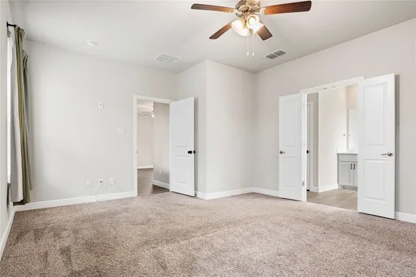 a view of an empty room with a chandelier fan
