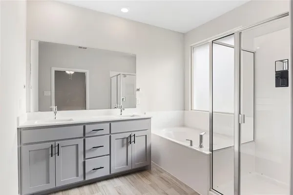 a bathroom with a tub sink and mirror