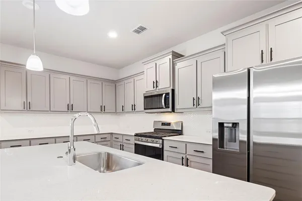 a kitchen with a refrigerator sink and microwave