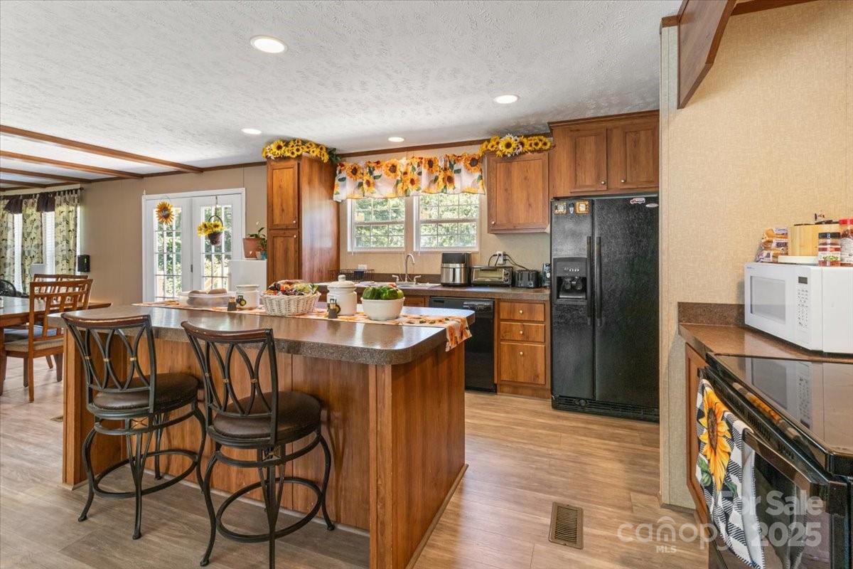 132 Bailey Mountain Road Mars Hill, NC 28754 - Photo 19 of 33 a kitchen with stainless steel appliances granite countertop a refrigerator a stove a sink a dining table and chairs