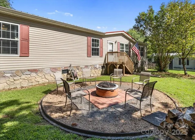 a view of a house with backyard sitting area and a garden