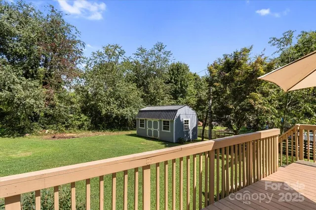 a view of a house with backyard and a trees