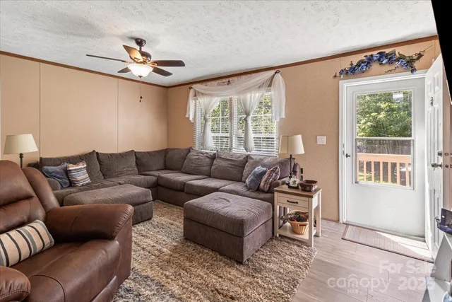 a living room with furniture ceiling fan and a window