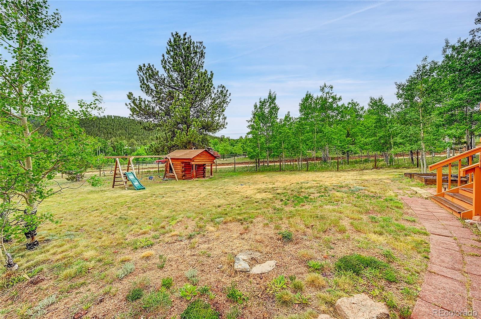 174 Saddlestring Road Bailey, CO 80421 - Photo 15 of 15 a backyard of a house with an outdoor space and seating area
