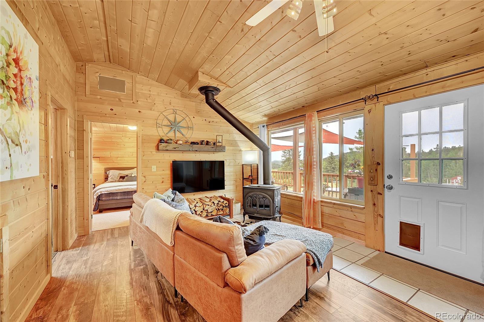 174 Saddlestring Road Bailey, CO 80421 - Photo 3 of 15 a living room with furniture wooden floor and a flat screen tv