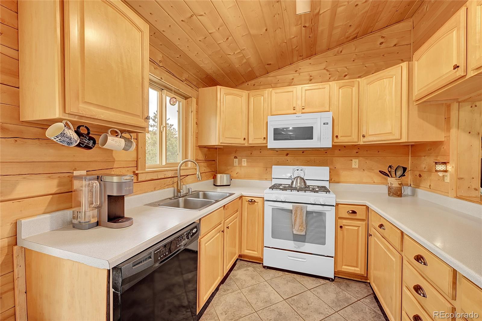 174 Saddlestring Road Bailey, CO 80421 - Photo 7 of 15 a kitchen with a sink stove and cabinets