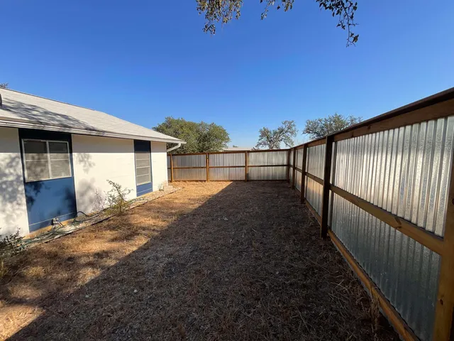 a view of a house with a wooden fence