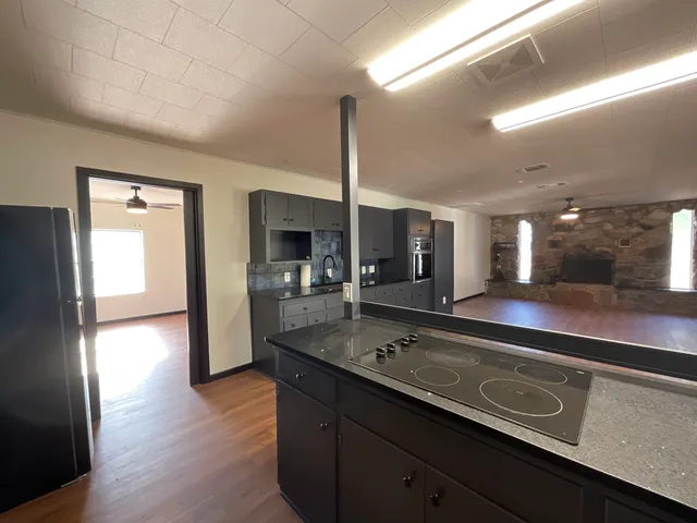 a kitchen with stainless steel appliances granite countertop a sink a stove and a wooden floors