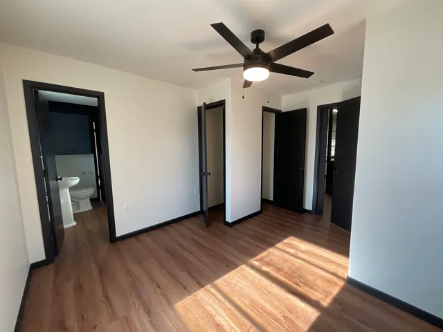 a view of a livingroom with wooden floor and a ceiling fan