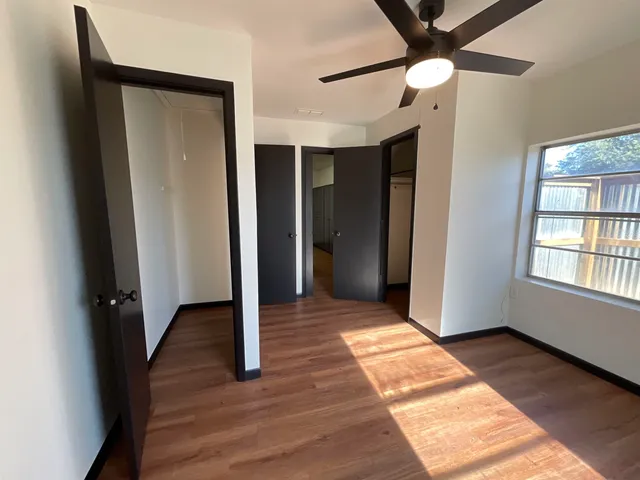 a view of hallway with window and wooden floor