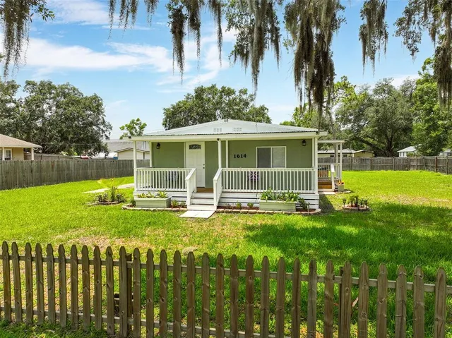 a view of a house with a yard and sitting area