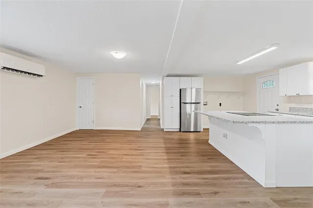 a view of large kitchen with granite countertop cabinets and wooden floor