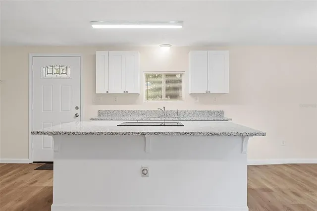a kitchen with granite countertop white cabinets and a sink