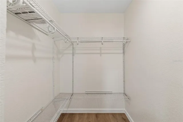 a view of walk in closet with empty racks