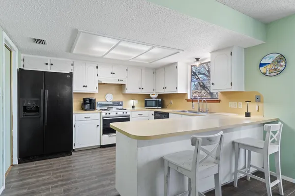 a kitchen with cabinets stainless steel appliances and wooden floor