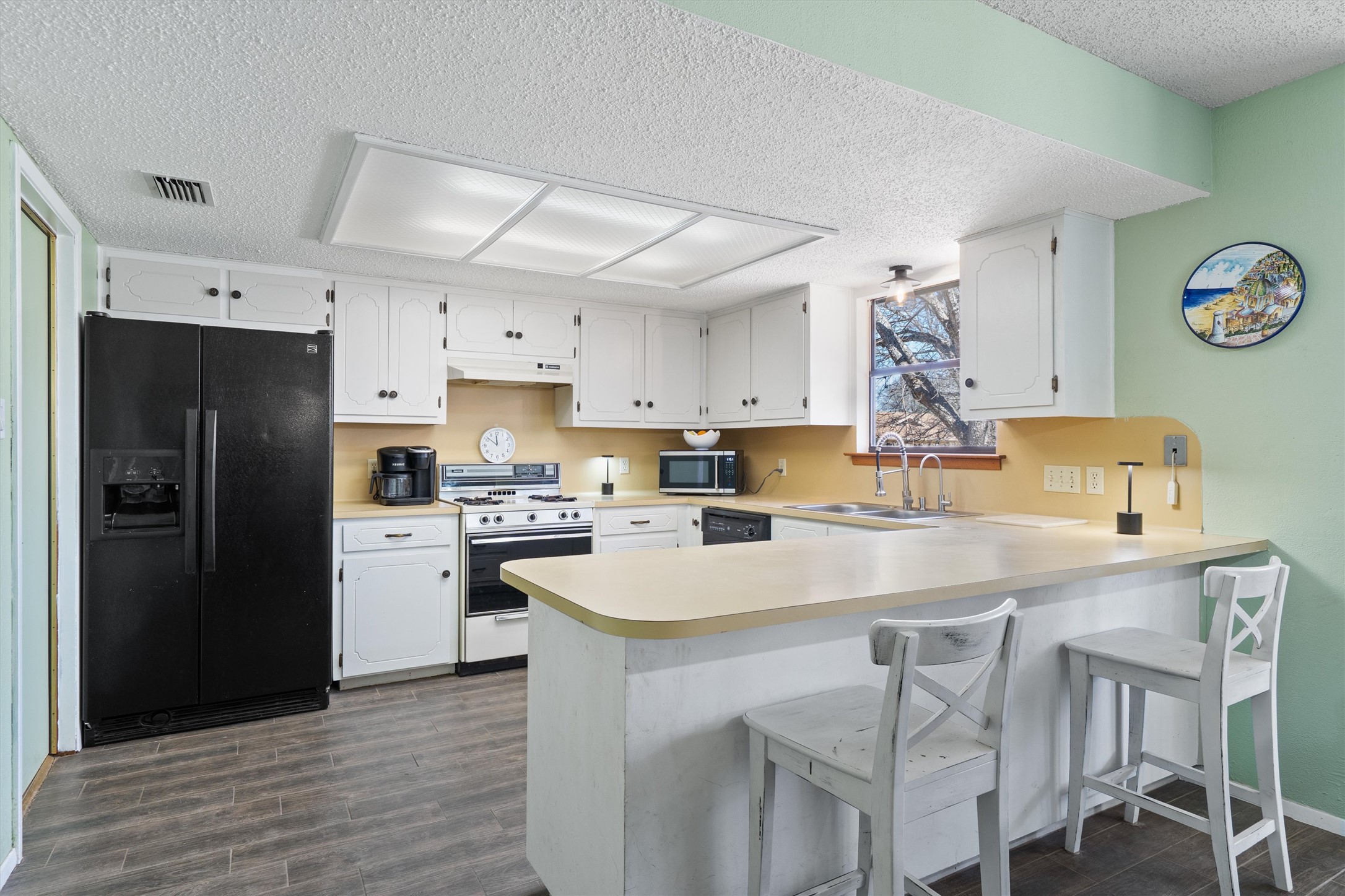 3309 Buffalo Springs Trail Georgetown, TX 78628 - Photo 13 of 36 a kitchen with stainless steel appliances a white refrigerator a sink a stove and chairs with wooden floor
