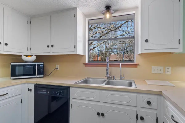 a kitchen with cabinets stainless steel appliances and sink