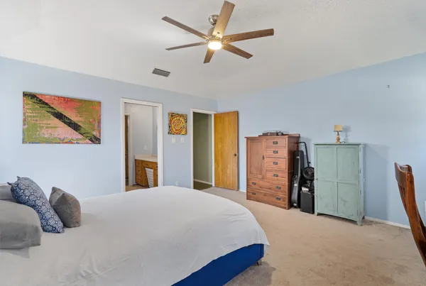 a bedroom with a bed and a refrigerator
