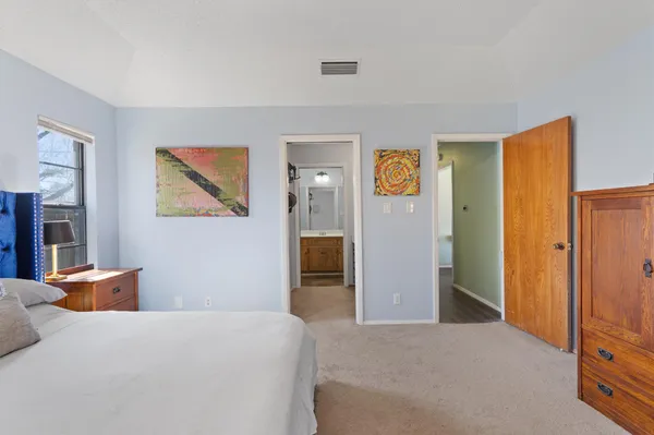 a bedroom with a bed and a painting on the wall