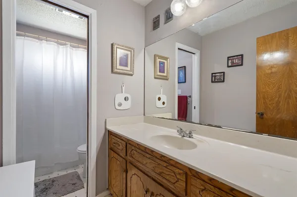a bathroom with a granite countertop sink toilet and shower
