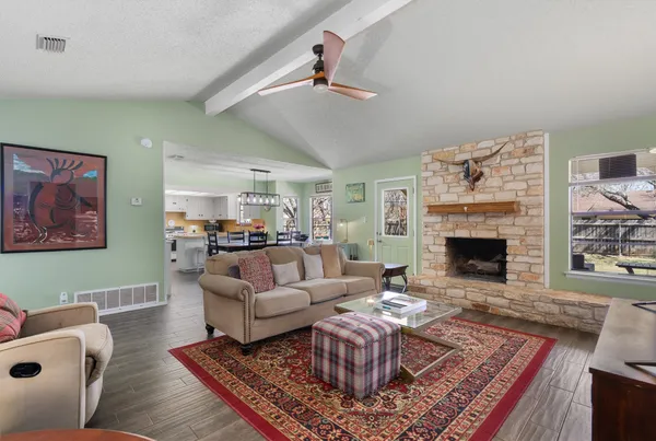 a view of a dining room and livingroom with furniture wooden floor a chandelier