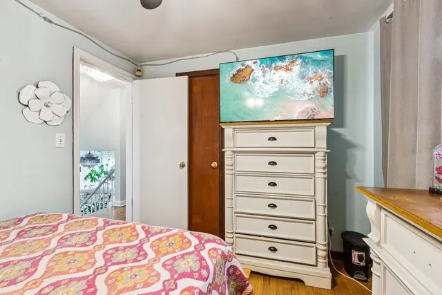 a view of a bedroom with a bed and a flat tv screen