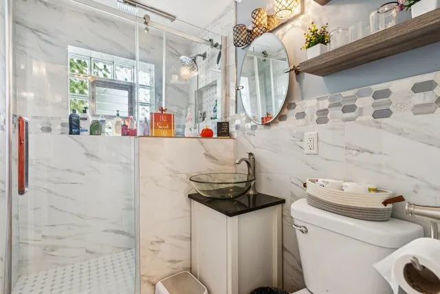 a bathroom with a sink a toilet and shower